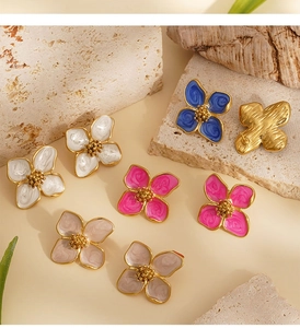 Vue détaillée de boucles d'oreilles florales en émail coloré sur un fond en pierre naturelle