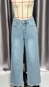 Détail de jean large bleu clair avec taille haute et finition aux bords effilés