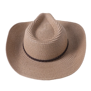 Détail de la texture en paille tressée et du ruban en cuir brun sur le chapeau de cowboy