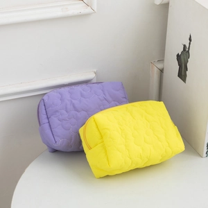 Detailed view of quilted flower pattern on colorful nylon makeup storage bags