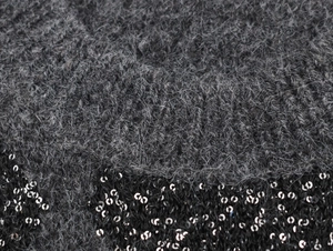 Macro detail of dark grey mohair knit fabric with sparkling black sequin accents