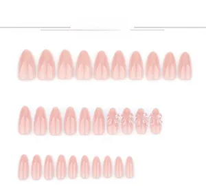Détail de faux ongles rose clair autocollants avec nœuds 3D et finition brillante amande