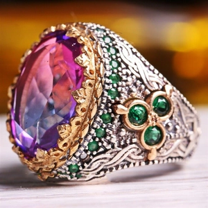 Macro shot of luxury vintage ring showing filigree metalwork and large colorful gemstone