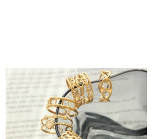 Detail of vintage gold hollow rings set with Roman numerals and anchor chain design