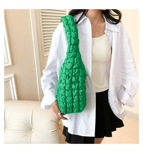 Vue détaillée d'un sac bandoulière vert matelassé avec texture gaufrée sur mannequin