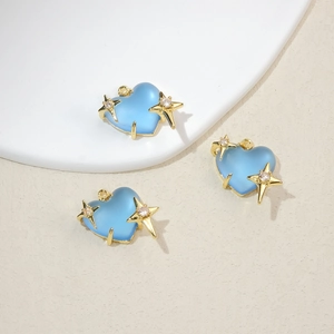 Detailed view of light blue heart pendants with gold stars and white zircon accents