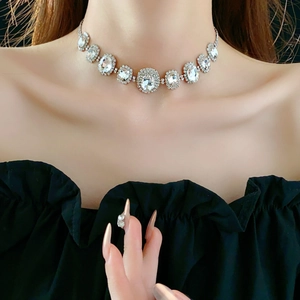 Close-up of elegant silver oval crystal necklace worn on neck with sparkling rhinestones