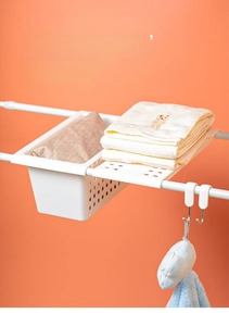 Panier de rangement suspendu blanc sur barre horizontale avec crochets de fixation