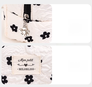 Detail of floral metal zipper and woven label on white quilted floral makeup bag
