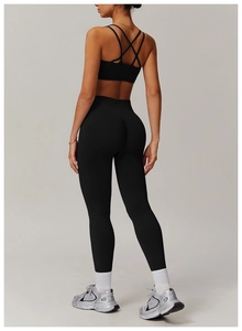 Detail of black cross-back sports bra and high-waist lift leggings on a model