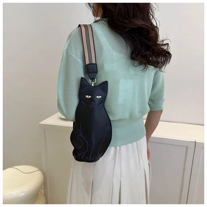 Detail of cute black cat crossbody bag with purple embroidery and striped webbing strap