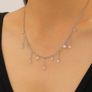 Detailweergave van zilveren kwastjesketting met sprankelende zirkonia-bedels op model