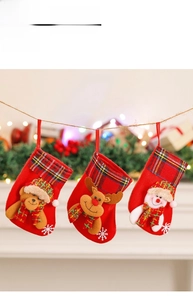 Close-up of three red Christmas stockings with plush bear, reindeer and snowman designs