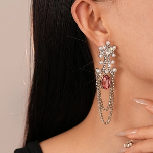 Detail of vintage silver earrings with pink gemstones, pearls, and tassel chains