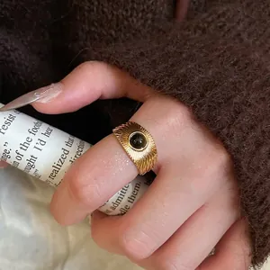 Vintage gold textured ring with round black tiger eye stone inlay worn on finger