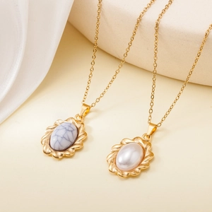Detail of gold stainless steel necklaces with marble and pearl oval pendants