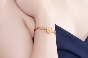 Nahaufnahme des goldenen Edelstahl-Armbands mit Unendlichkeitssymbol am Handgelenk