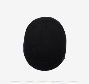Close-up of black ribbed knit beanie showing fine texture and side logo patch detail