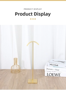 Detailed view of luxury gold metal necklace display stand on a wooden surface