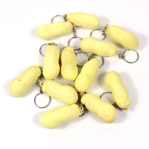 Macro shot of twelve realistic peanut-shaped keychains in light yellow plastic finish