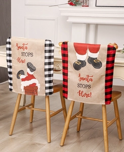 Detail of burlap Santa chair covers with buffalo plaid edges for festive dining decor