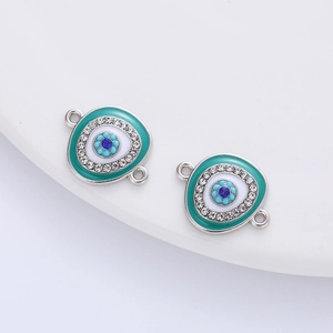 Detailed close-up of teal enamel evil eye charm with rhinestones and double-ring connectors