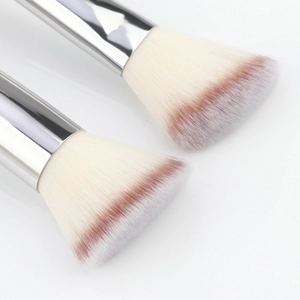Detail of dual-tone gradient bristles and silver aluminum ferrule on soft makeup brushes