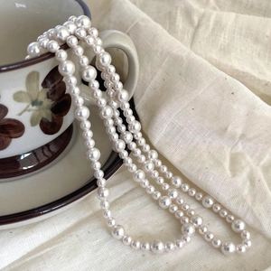 Elegant 925 sterling silver pearl necklace draped on a vintage ceramic cup in a French style