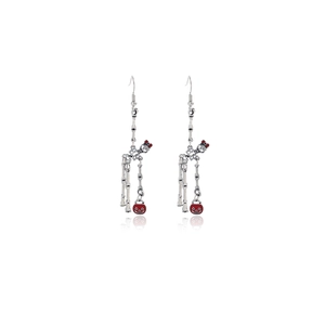 Detail of silver skeleton earrings with red pumpkin lanterns and bows for Halloween