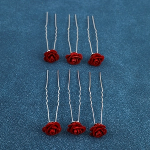 Detail of red rose U-shaped hair pins with velvet texture for bridal wedding styling