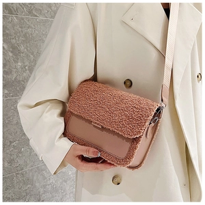 Detail view of the fuzzy lamb wool stitching and smooth leather texture on pink square bag