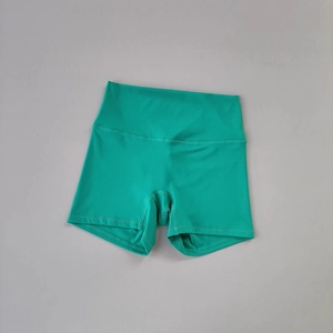 Dettaglio dei pantaloncini da yoga verde smeraldo a vita alta con cuciture piatte rinforzate