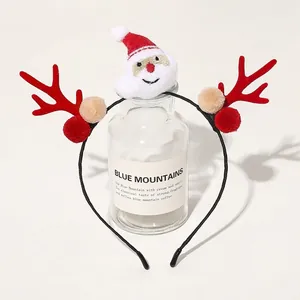Detailed view of a Christmas headband with reindeer antlers and Santa plush on a glass bottle