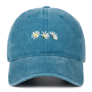 Dettaglio del ricamo a margherita bianca su berretto in cotone lavato blu navy