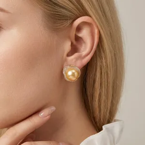 Boucles d'oreilles perles dorées avec bordure cristal sur profil de mannequin femme