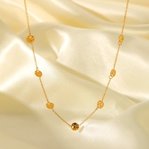 Detailed macro view of 18K gold-plated hammered disc pendants on stainless steel chain