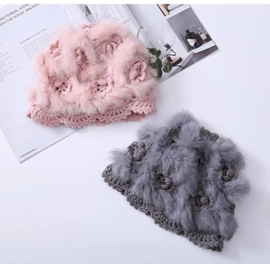 Detailed knit texture of crochet winter hats with faux fur trim in pink and gray