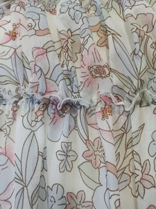 Close-up of floral print chiffon fabric with elastic smocked texture in pastel tones