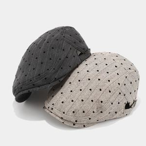 Grey herringbone newsboy caps with embroidered heart patterns and metal buckles