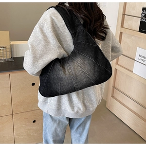 Sac croissant en denim noir délavé porté par un mannequin pour l'effet de taille