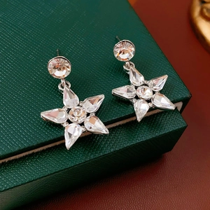 Macro shot of silver star drop earrings with sparkling rhinestones on a vintage jewelry box
