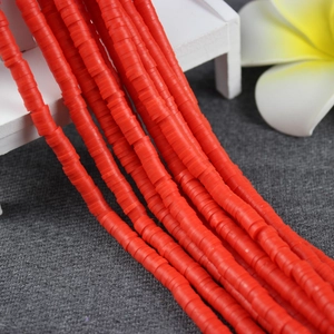 Detailed view of red flat round polymer clay spacer beads for DIY jewelry making