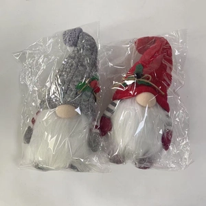 Detail of gray and red Christmas forest gnome dolls in individual plastic bag packaging