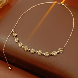 Close-up of gold necklace with round yellow-green gemstone on brown leather background