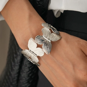 Detail of silver butterfly cuff bracelet featuring intricate wing texture on wrist