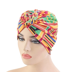 Ethnic floral turban hat with vibrant geometric patterns and twisted rose knot detail