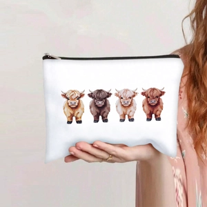 Handheld view showing four cartoon highland cows printed on a white canvas makeup pouch