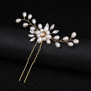 Close-up of handmade gold flower bridal hair pin with pearls and crystals