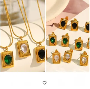 Detail of gold emerald necklace and earrings set featuring rectangle frame drop pendants