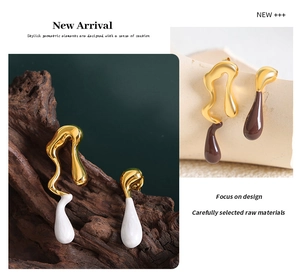 Macro detail of asymmetric teardrop earrings with gold plating and white enamel finish